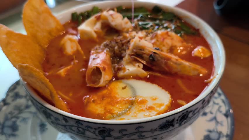 Close Up Spicy Seafood Noodle Soup with Shrimp and Squid in Bowl
