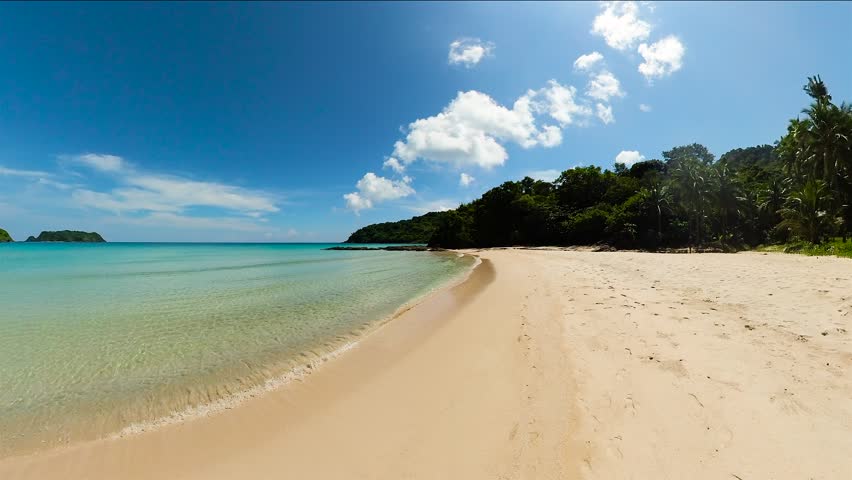 Tropical sandy beach and ocean waves. Diapela Beach. El Nido. Palawan. Philippines.