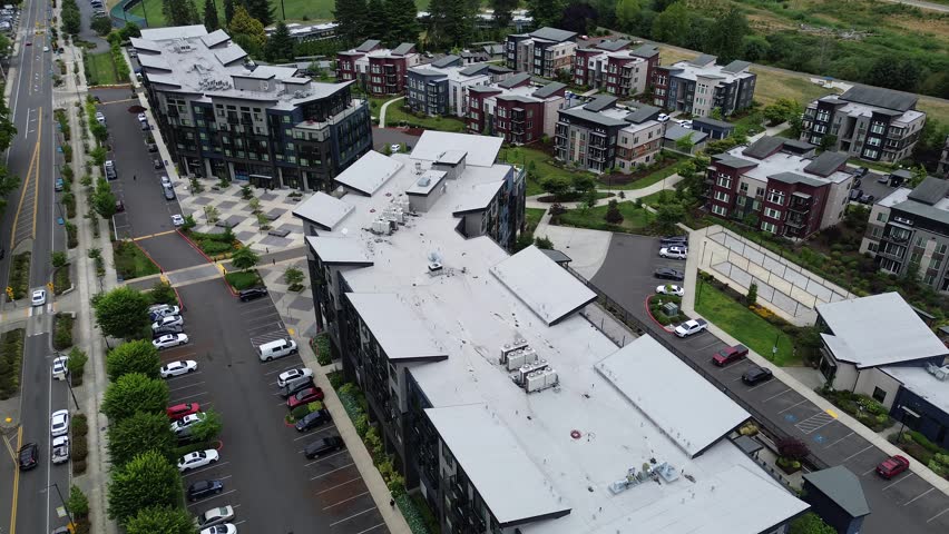 West Meeker Street intersects downtown Kent suburbs Seattle. Modern architectural units dominate residential compound layout, featuring expansive parking lots near Riverbend Golf Complex, Kent, WA. US