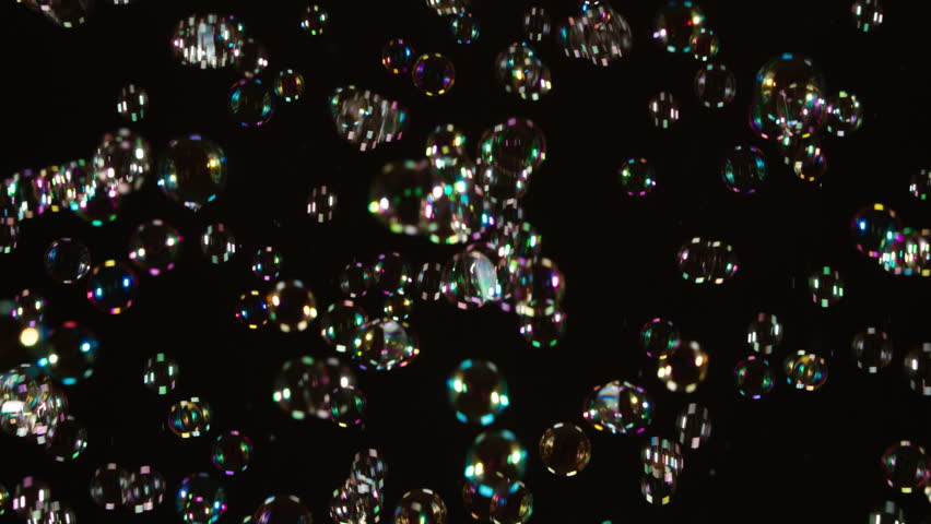 Shimmering Soap Bubbles on Black. A large number of soap bubbles moving in one direction against a black background. Great for use in blending