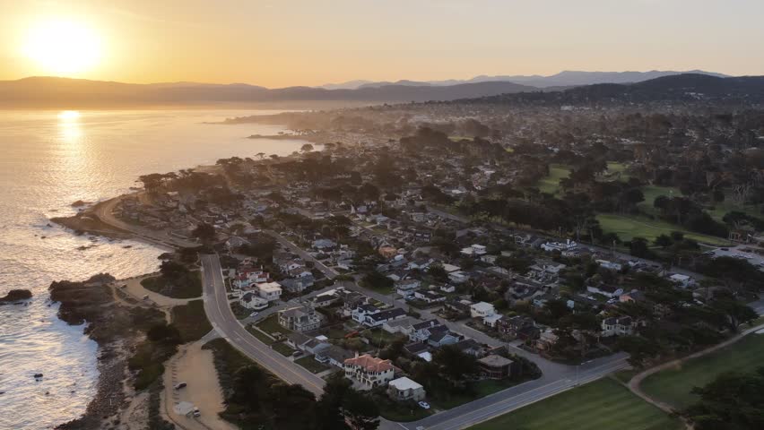 Monterey coastline aerial view with ocean waves, rocky shore, homes and golf course in California, USA. g.