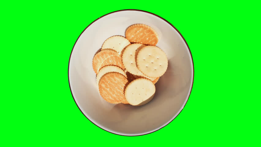 Biscuits in a ceramic bowl, green screen background.