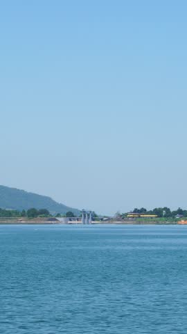 Scenic view of water reservoir lake and rolling hills under clear blue sky