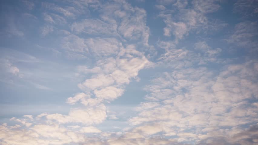 Wispy white clouds drift slowly across a bright blue sky over Aarhus on a clear day.