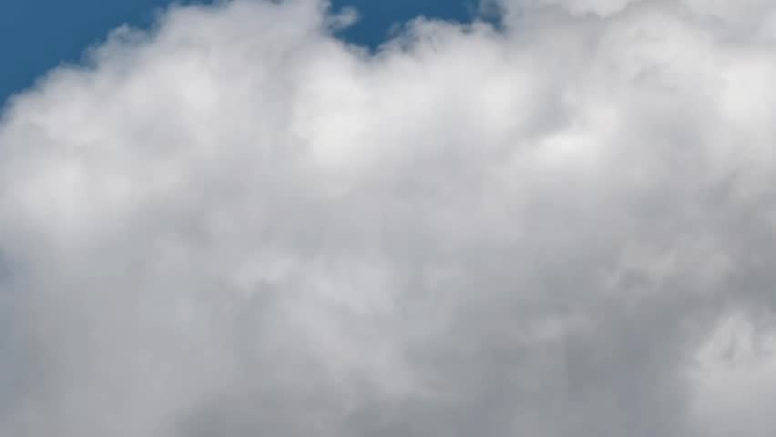 Dense white clouds fill the sky, with faint patches of blue visible at the top. Soft lighting creates a textured and fluffy cloud appearance, suggesting an overcast or partly cloudy day.