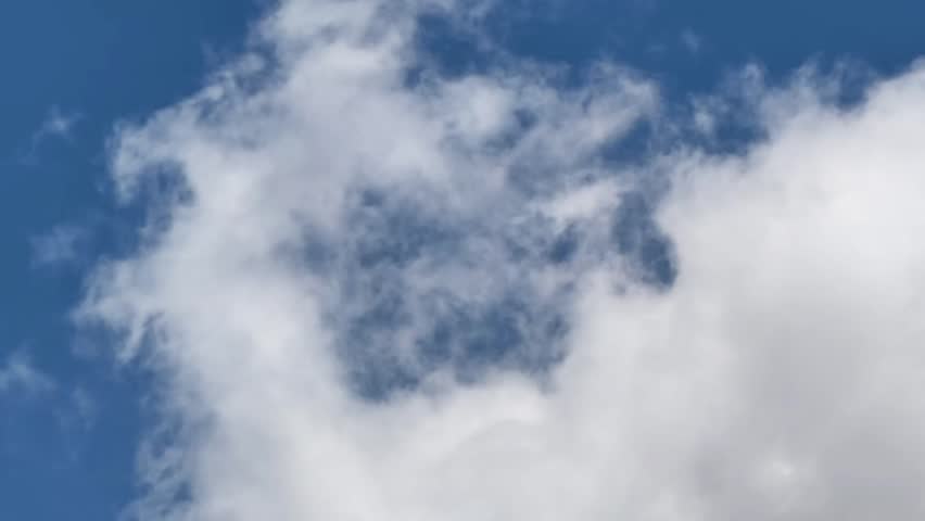 White clouds in a blue sky, showing a natural and airy scene with soft cloud formations and open space.