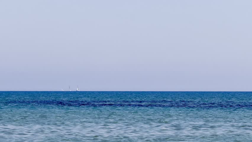 A sailing yacht is sailing on the sea. Ships and yachts sail near the coast and beaches.