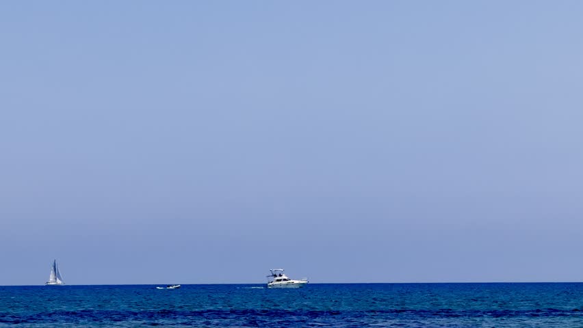 A sailing yacht is sailing on the sea. Ships and yachts sail near the coast and beaches.