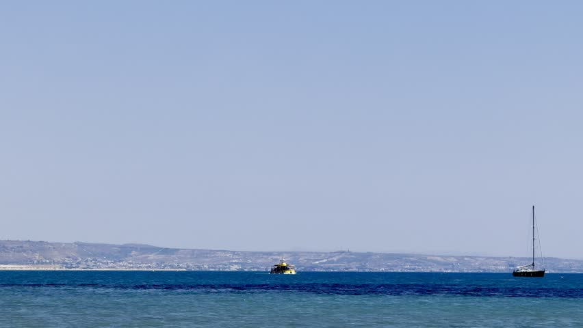 A sailing yacht is sailing on the sea. Ships and yachts sail near the coast and beaches.