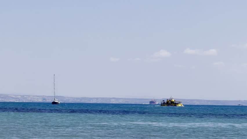 A sailing yacht is sailing on the sea. Ships and yachts sail near the coast and beaches.