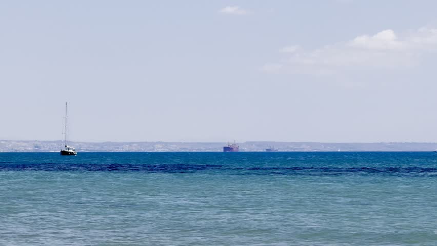 A sailing yacht is sailing on the sea. Ships and yachts sail near the coast and beaches.