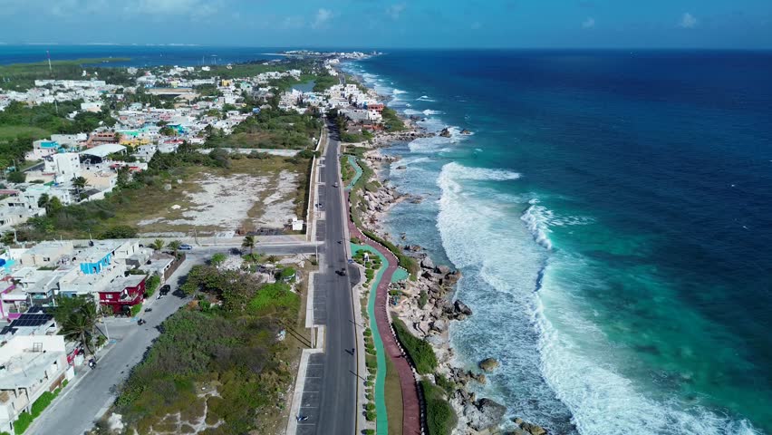 Cinematic drone view of both coastlines from the narrow middle section of Isla Mujeres, Mexico