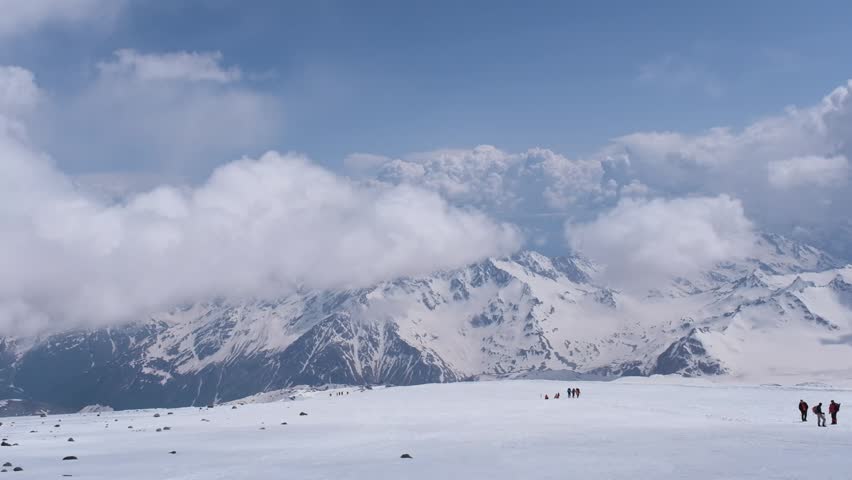 Climbers on the slopes of Mount Elbrus with the Semerka Glacier and Mount Ushba in the background