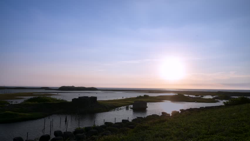 Stunning sunset view over the coastal wetlands and water in Miaoli, Taiwan, featuring a colorful evening sky and tranquil water reflections.
