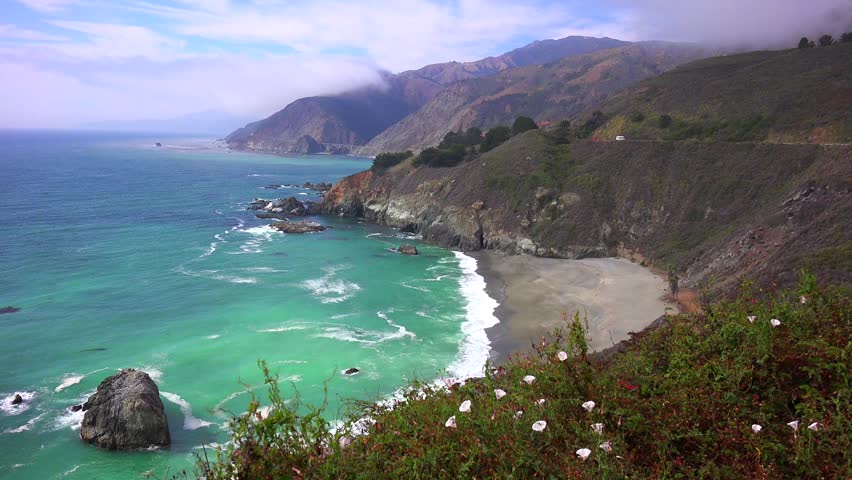 Dramatic cliffs, ocean waves, coastal road, scenic vista.