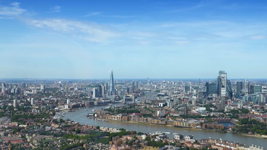 Rear view of a tourist woman looking at the panoramic view of the skyline of London, England, during a sunny summer day