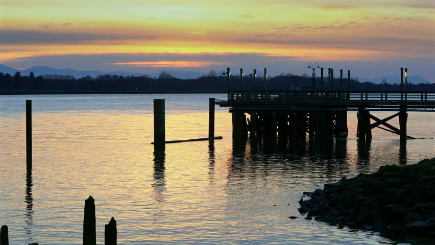 Fraser River Fishing Pier Sunset Richmond 4K UHD. Sunset behind a fishing pier on the Fraser River. British Columbia, Canada. 4K, UHD.
