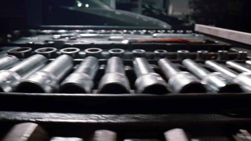 A large set of spanners of various sizes in a pull-out drawer at a car repair workshop 