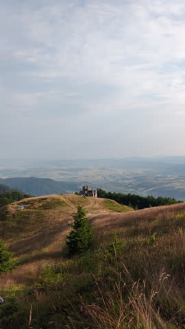 Old stone ruins on mountain peak overlooking vast scenic valley