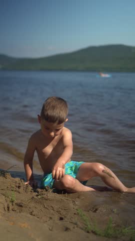 Little Boy Building a Sandcastle on the Beach During Summer