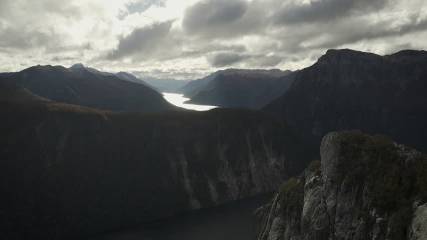 Panoramic landscape view from La Mirada del Doctor viewpoint, showcasing dramatic mountain ranges and a reflecting lake in Nahuel Huapi National Park, Patagonia, Argentina.