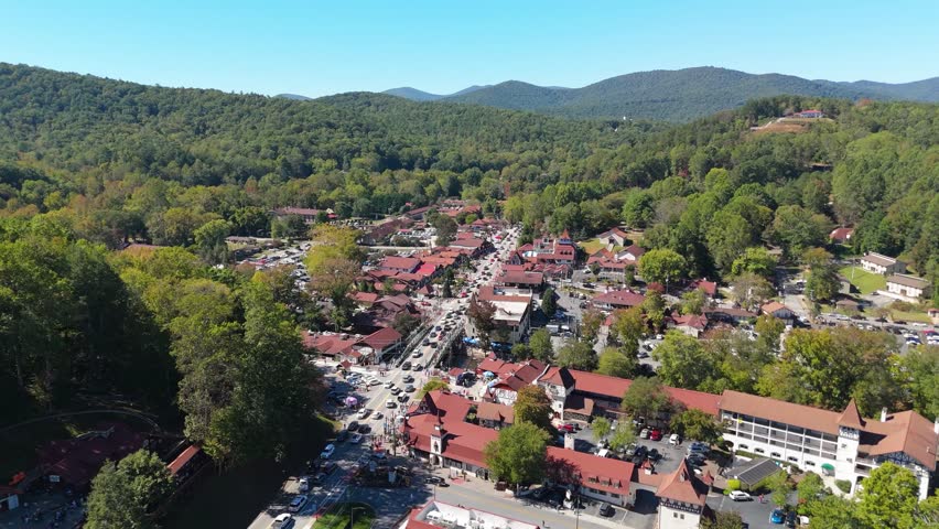 Dynamic aerial footage of small town nestled in lush green mountains.