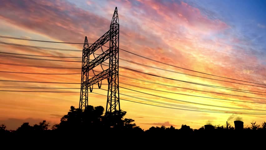 Silhouettes of electrical towers and power lines against a stunning sunset sky filled with vibrant colors and dramatic cloud formations in a tranquil setting.
