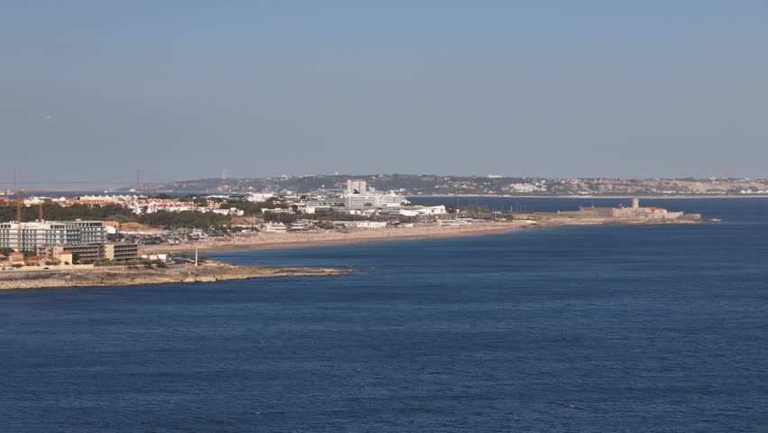 Aerial view of Carcavelos beach with its sandy shore, coastal buildings, and the Atlantic Ocean in Cascais, Lisbon, Portugal.