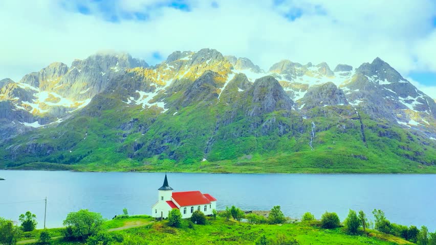 Aerial View of an Isolated House Beside a Lake With a Green Mountain Backdrop