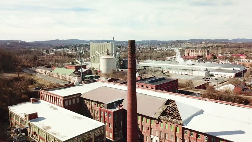 Aerial view of abandoned mill and industrial area during daytime.