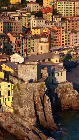 Vertical video: drone shot of colorful Italian town of Camogli in Liguria near Genoa, luxury resort on Italian Riviera at sunset, orbiting aerial view of Italian coastal village. High quality 4k footage