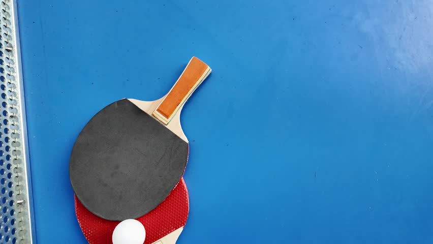 Table tennis paddles and ball on ping pong table