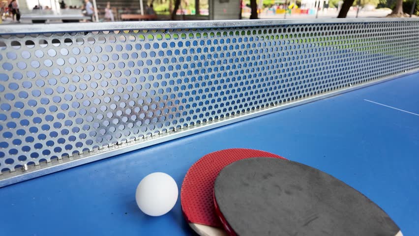 Table tennis paddles and ball on ping pong table