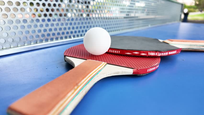 Table tennis paddles and ball on ping pong table