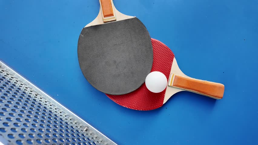 Table tennis paddles and ball on ping pong table