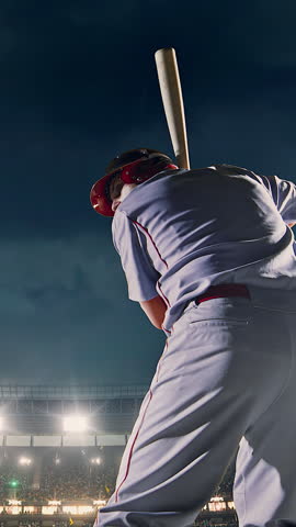 Baseball batter full swing follow-through with bat raised at night stadium