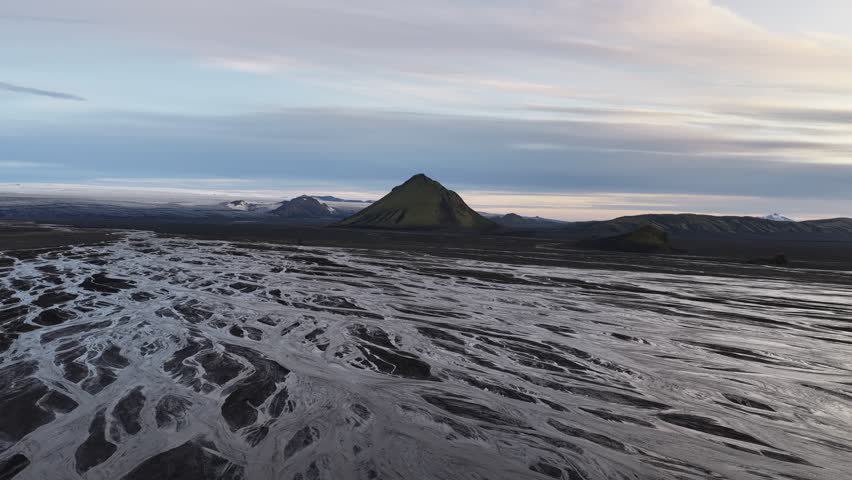 Aerial view of Maelifell volcano with its mossy green slopes surrounded by braided river channels in the volcanic landscape of Skaftarhreppur, Iceland.