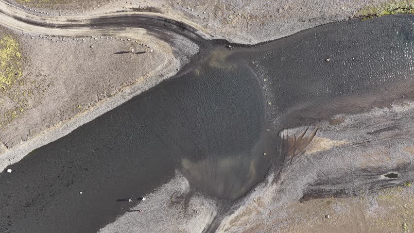 Aerial view of a winding river flowing through the volcanic landscape of the Highlands, Iceland.