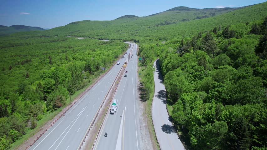 Cars Driving Through Highway Passes Through Dense, Forested Terrain In White Mountain National Forest In New Hampshire, USA. - aerial shot