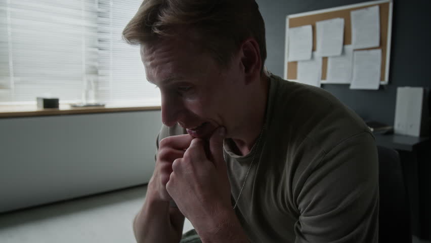 Young Caucasian veteran man talking during therapy session, touching chin anxiously. Footage for mental health campaigns, PTSD support, and counseling advertisements