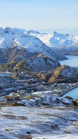 Panoramic video of Unalaska and Dutch Harbor town on Aleutian Islands, Alaska. Industrial infrastructure with oil storage tanks, warehouses, seafood processing plants and commercial harbor