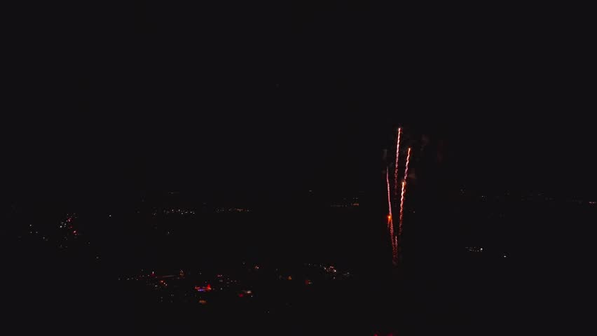 View of vibrant red fireworks exploding in the night sky over the town of Paradise, Pennsylvania, United States.