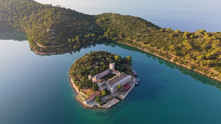 Saint Mary Island monastery surrounded by turquoise lake waters on Mljet, aerial view of famous Croatian landmark. Picturesque Saint Mary Island in the middle of Great Lake on Mljet, Croatia 