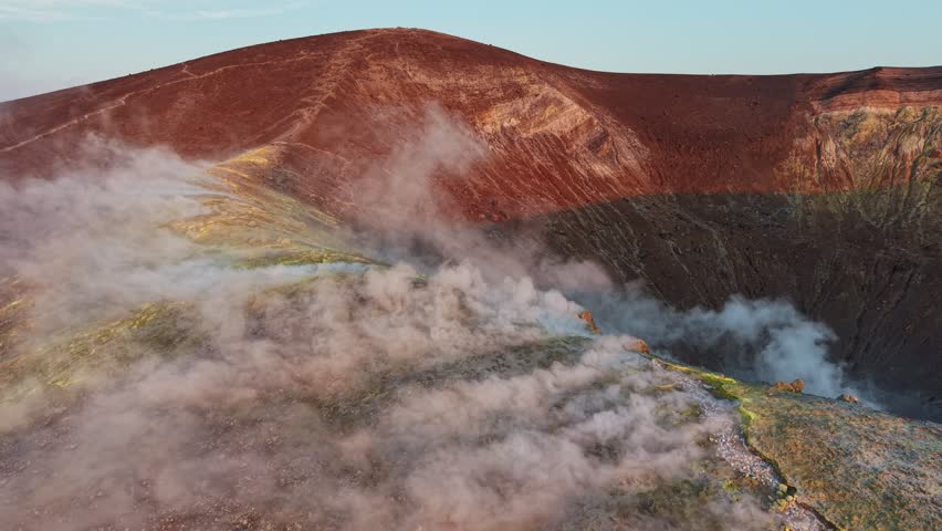 Dramatic smoke rising from sulfur vents on Vulcano island, Sicily. Volcano crater rim, raw nature force in Aeolian islands. Vulcano crater yellow sulfur minerals emitting dense white smoke