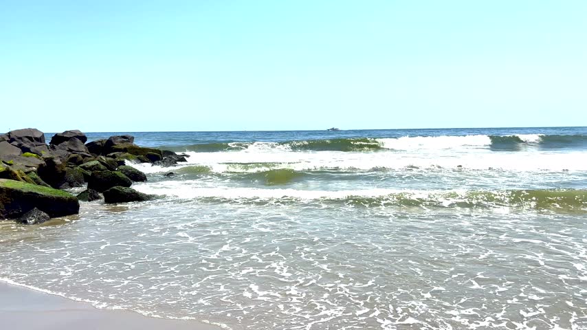 Many Atlantic Ocean waves rolling on to a jetty at Asbury Park beach in New Jersey.