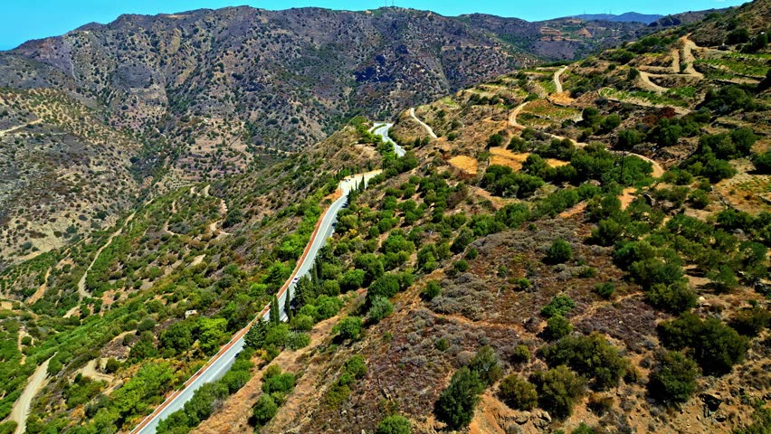Aerial view of a winding road cutting through the rugged mountainous landscape of Crete, Greece.