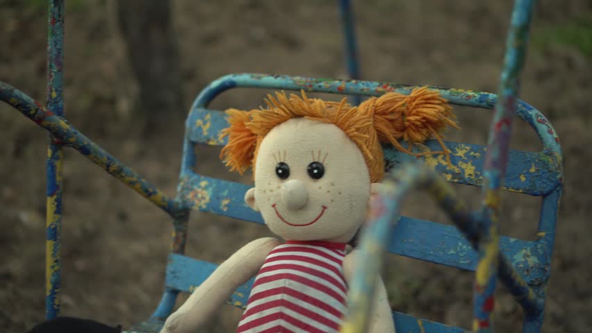 Creepy Plush Girl Doll Swinging on Old Swings in an Abandoned Park