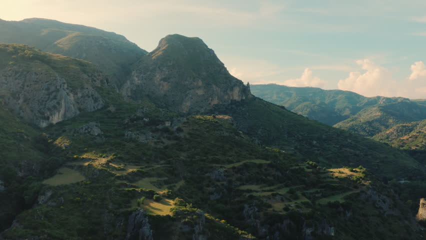 Expansive mountain valley under soft sunlight