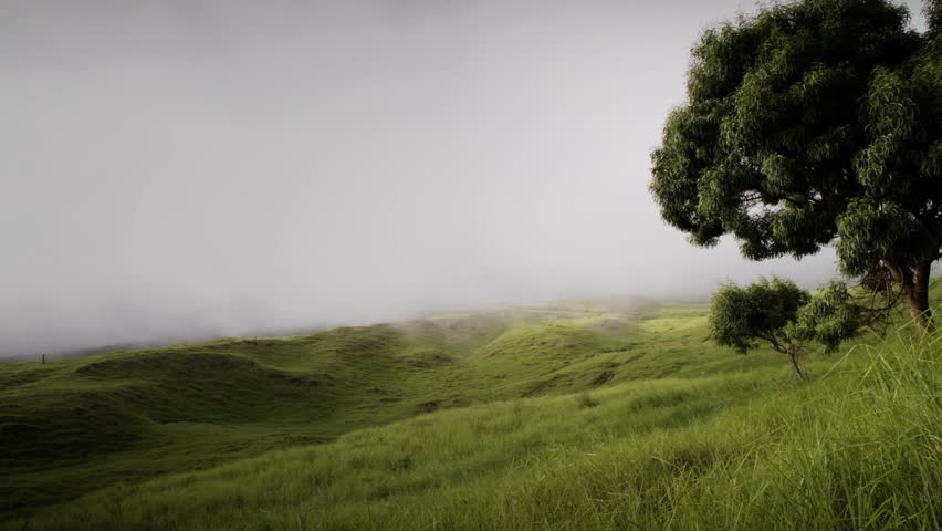 Time lapse view of clouds rolling over green grassy hills.