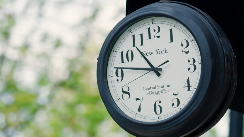 Classic outdoor clock with New York inscription, captured in soft daylight with a blurred background